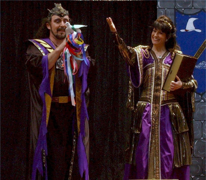 Markus Steelgrave magically produces a white dove as Angelique Steelgrave looks on. Wizard themed magic show for a Harry Potter novel release